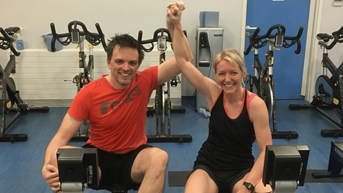 Two people sitting on a rower celebrating.