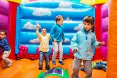Children bouncing on a bouncy castle.