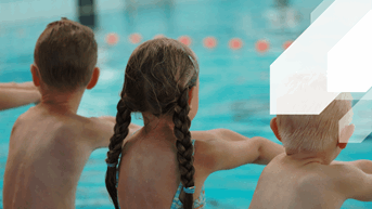 Two boys and a girl sitting on poolside ready for their Crash Course Swim Lessons